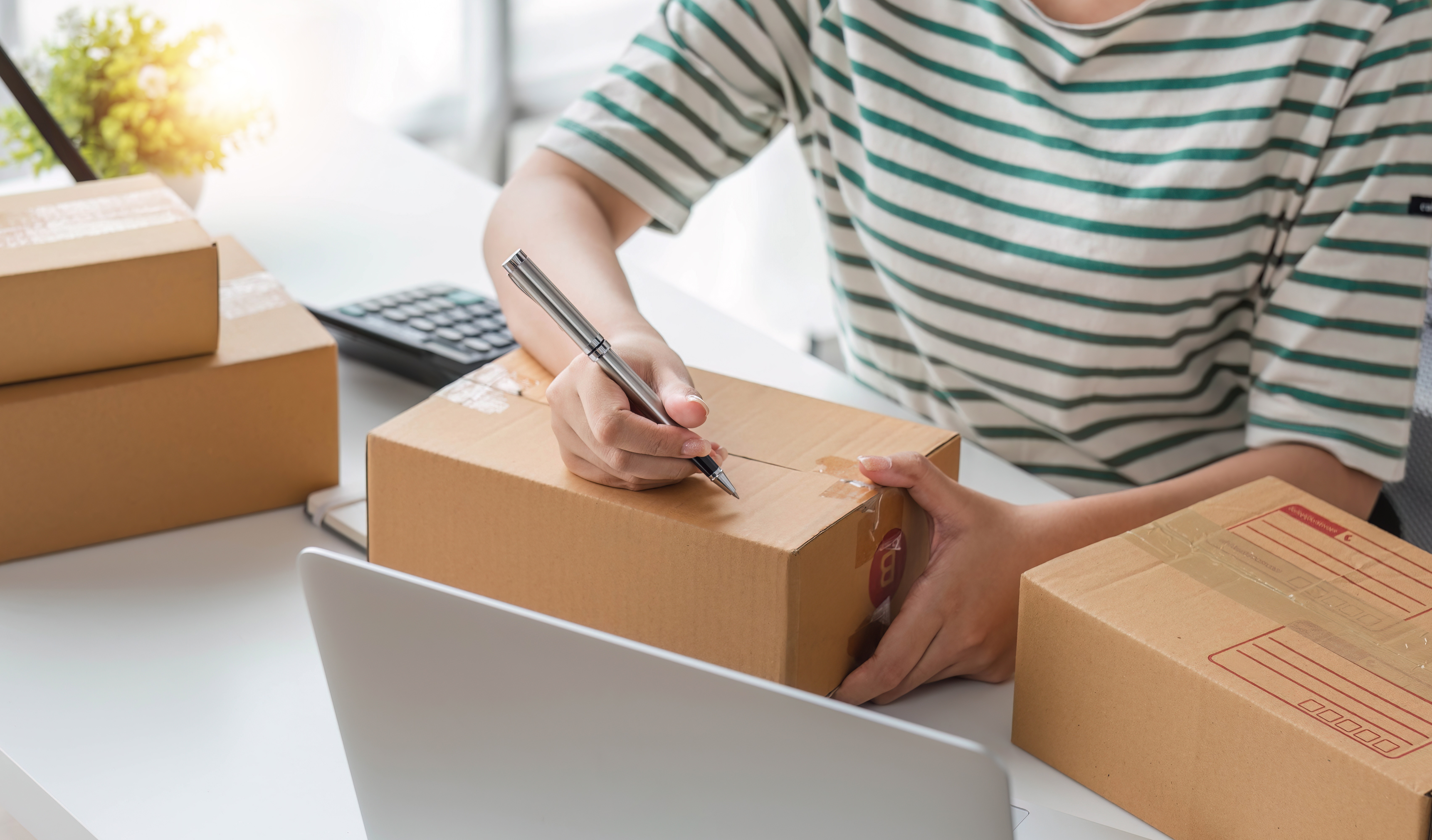 Mulher preparando encomenda para enviar pelos Correios
