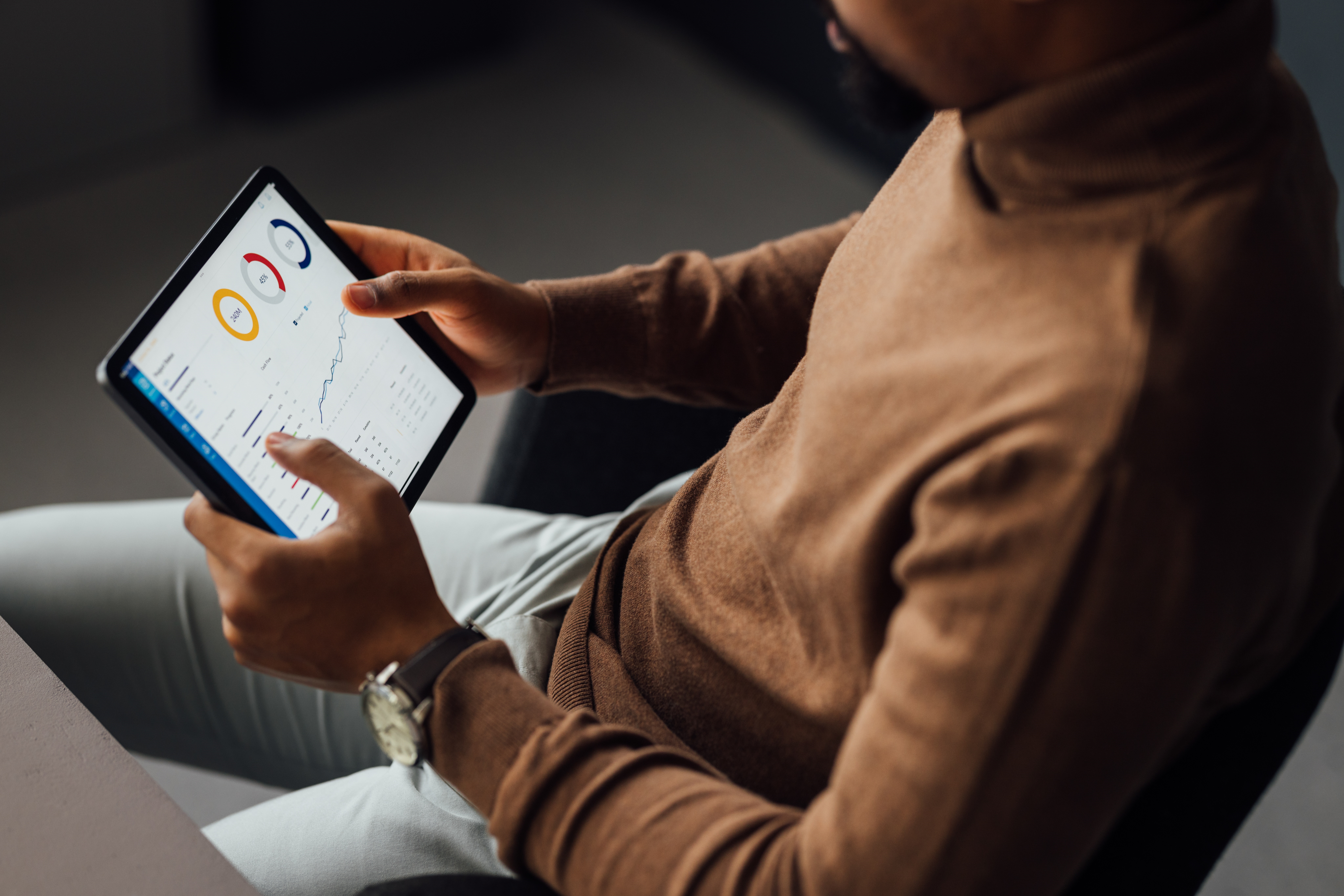 Homem analisando o GMV do negócio em tablet