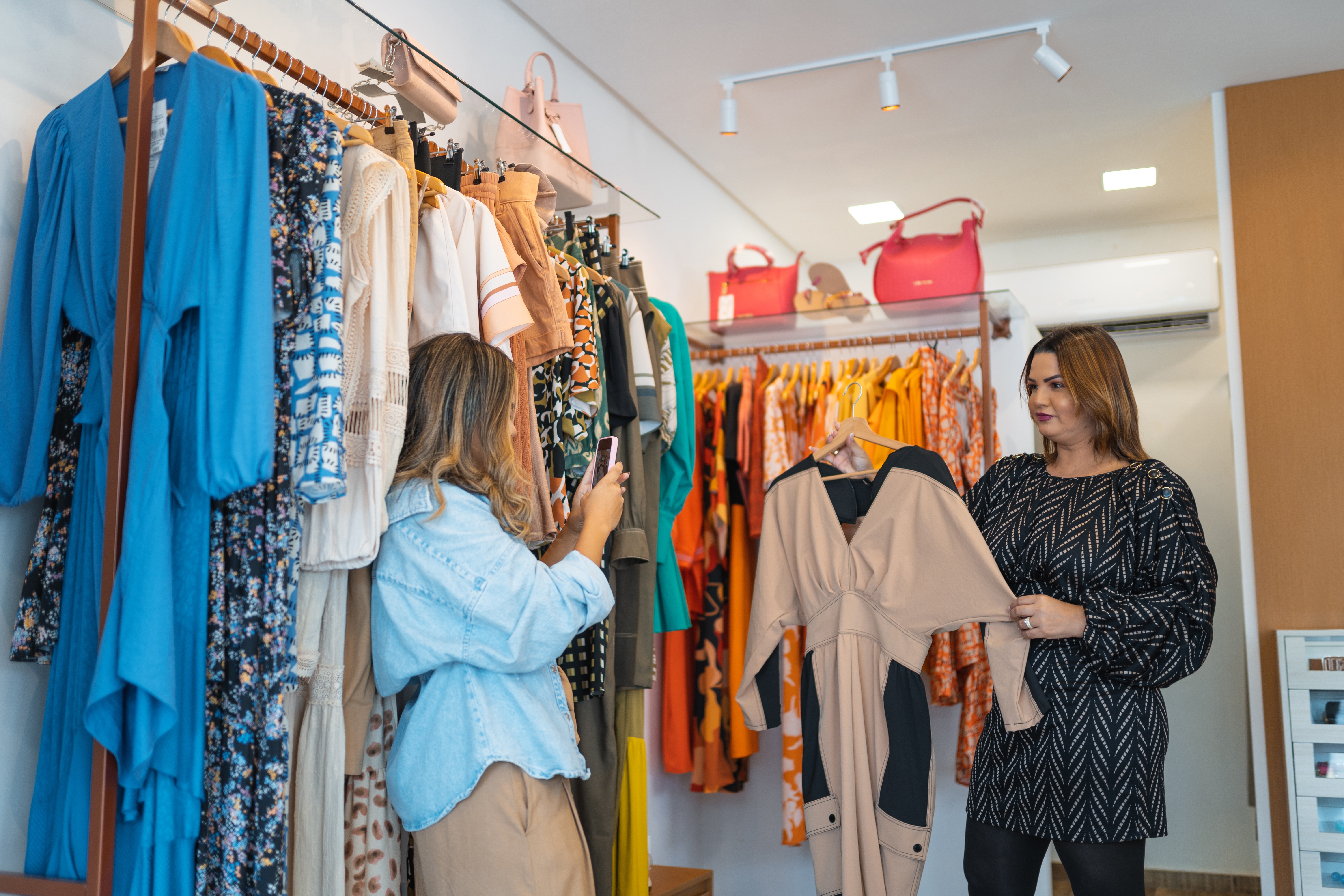Empreendedoras tirando fotos de roupas para revender