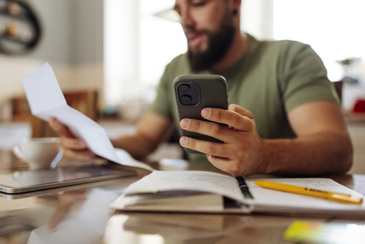 Dono de uma pequena empresa fazendo a gestão financeira no celular