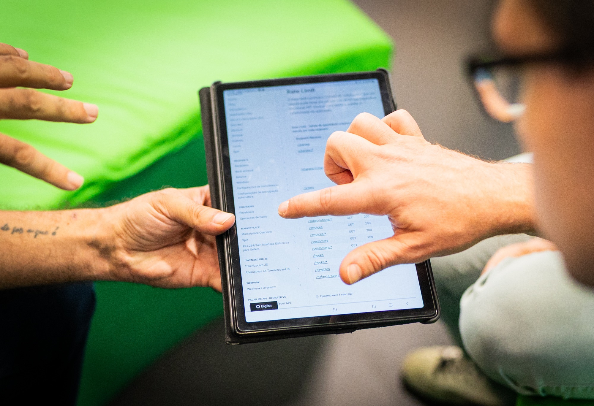 Homem apontando para tela de tablet com documentação do Pagar.me