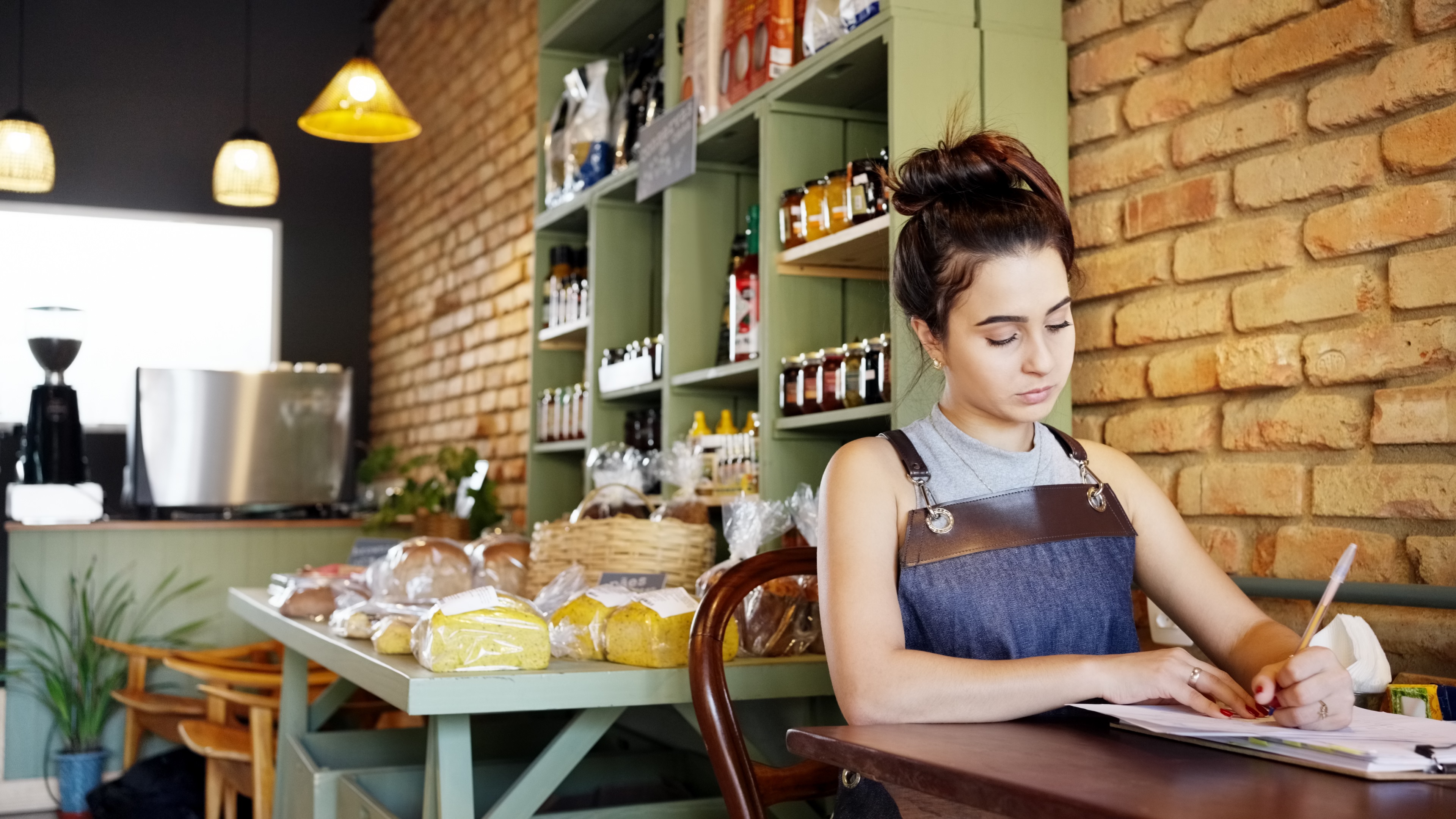 Empreendedora fazendo planejamento financeiro em caderno