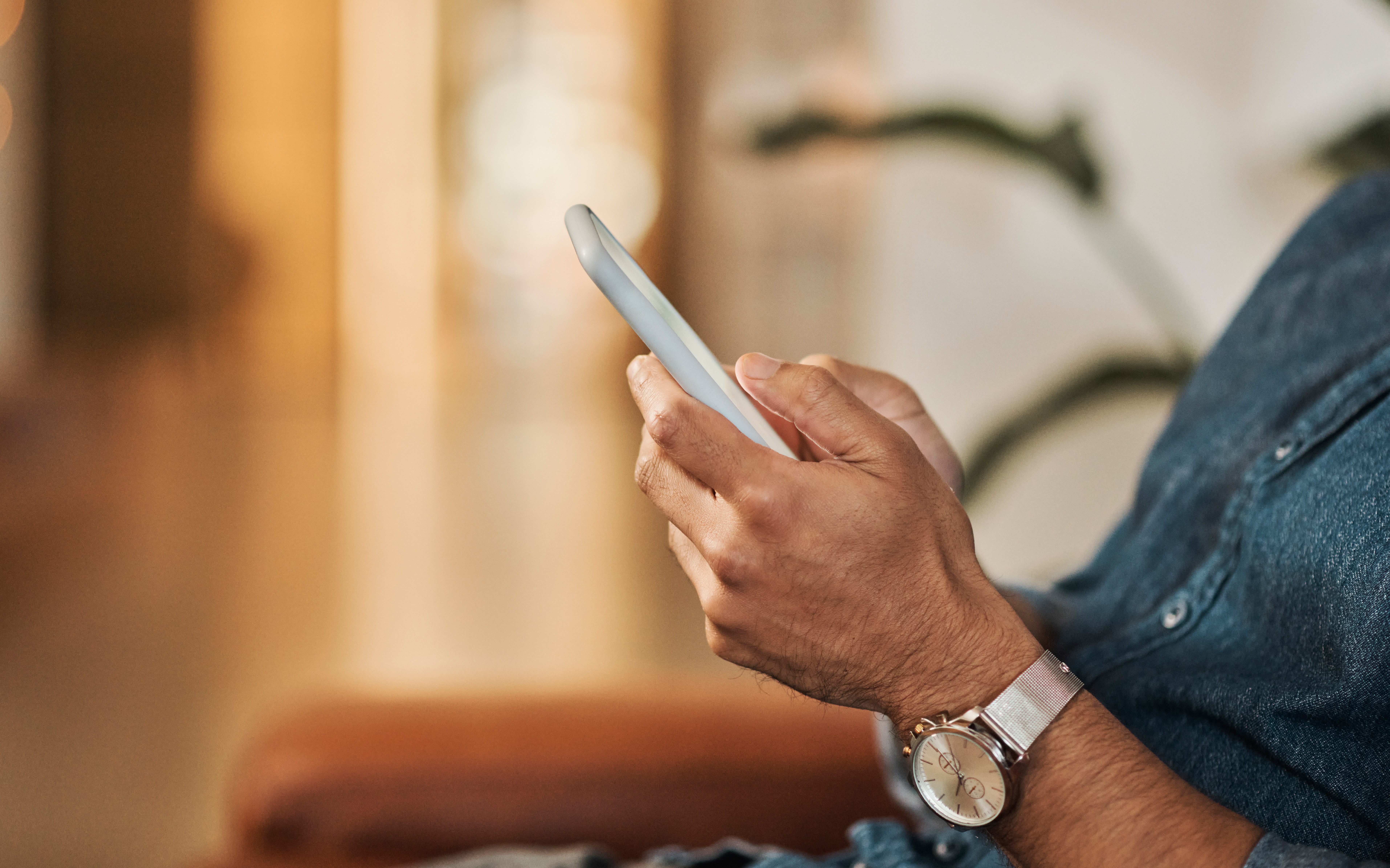 Mão de um homem mexendo no celular