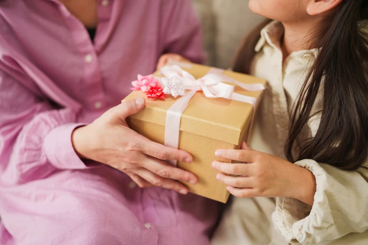 Filha dando presente de Dia das Mães para a mãe
