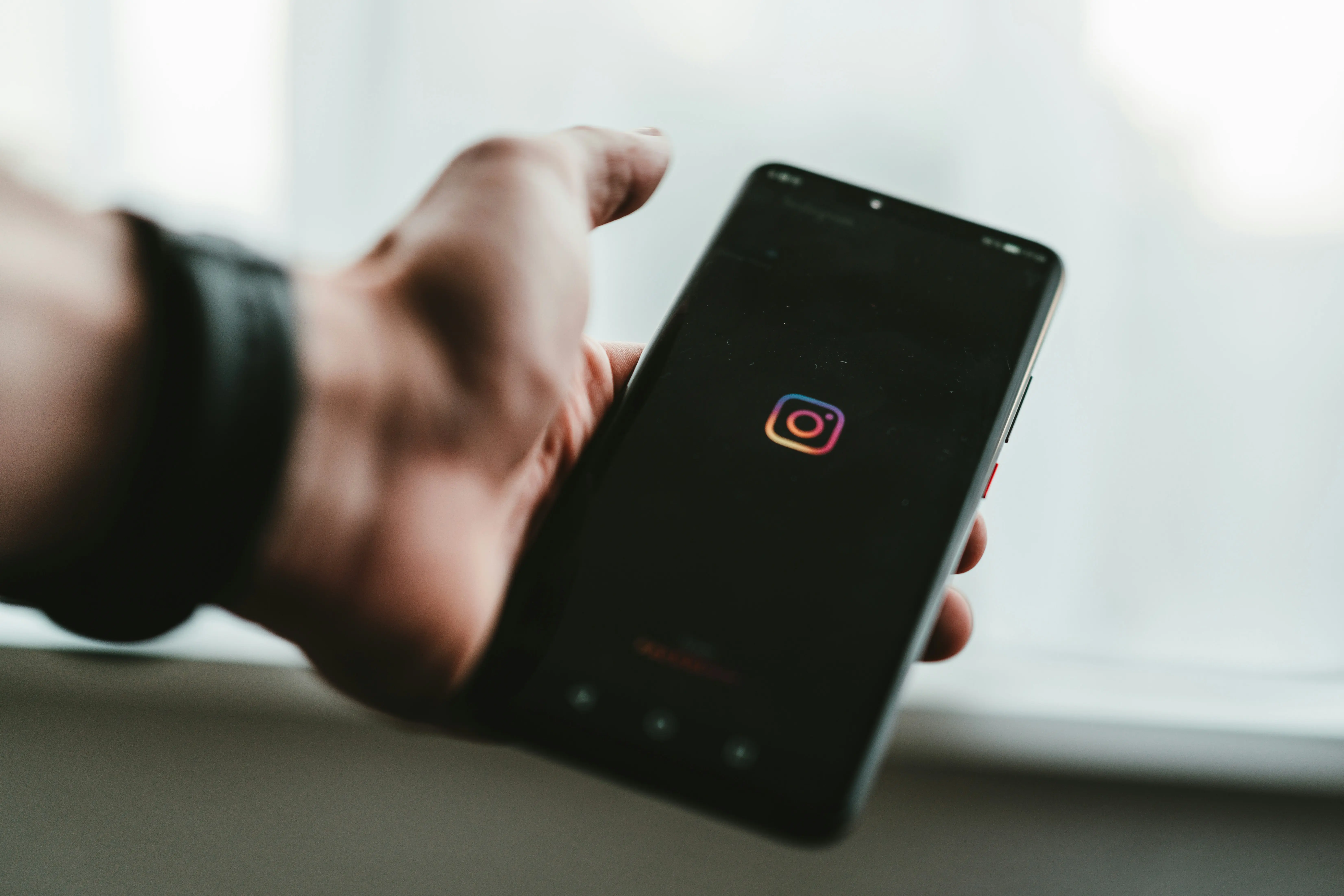 Homem segurando celular com a tela do Instagram Ads