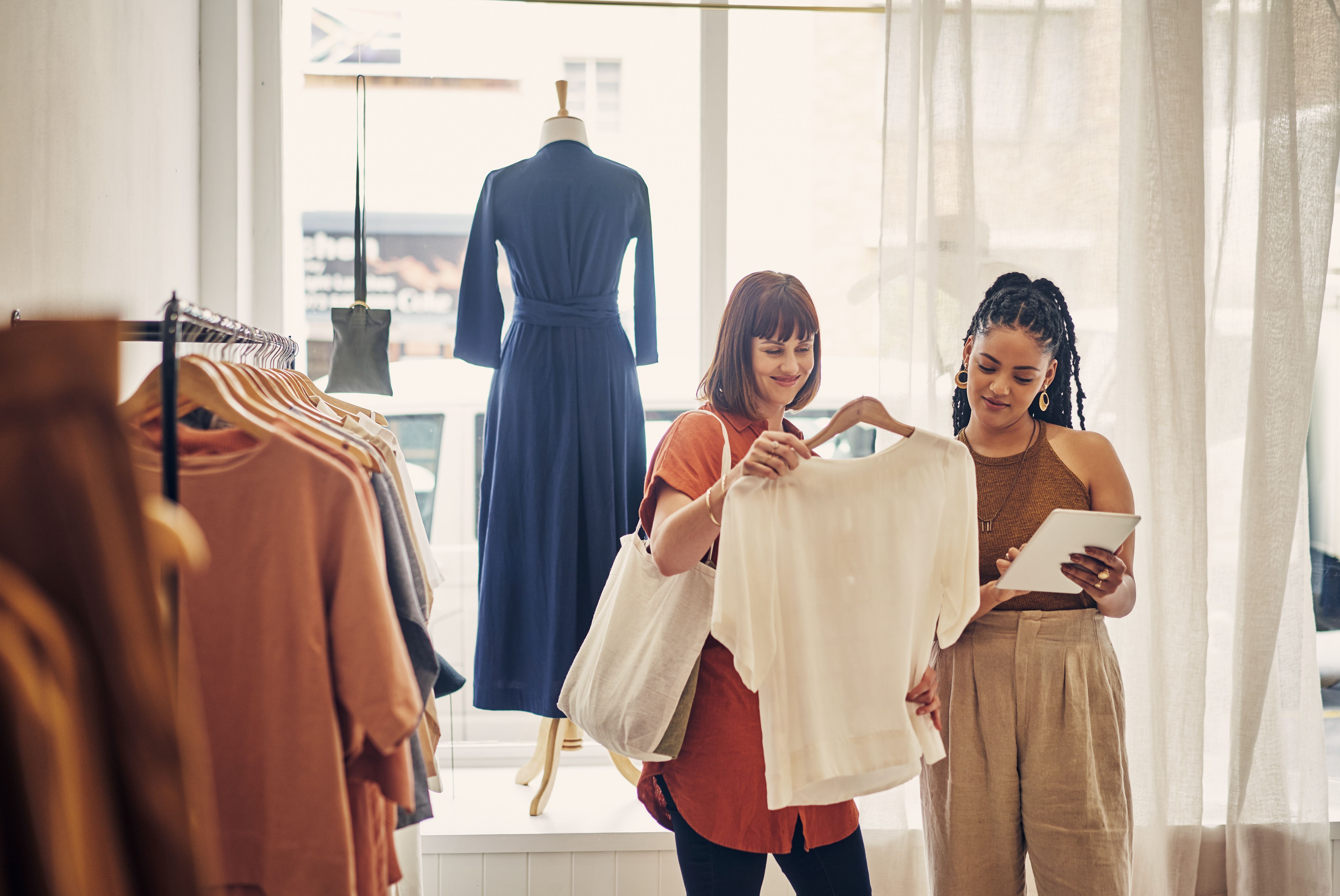 Duas mulheres olhando roupas em uma loja