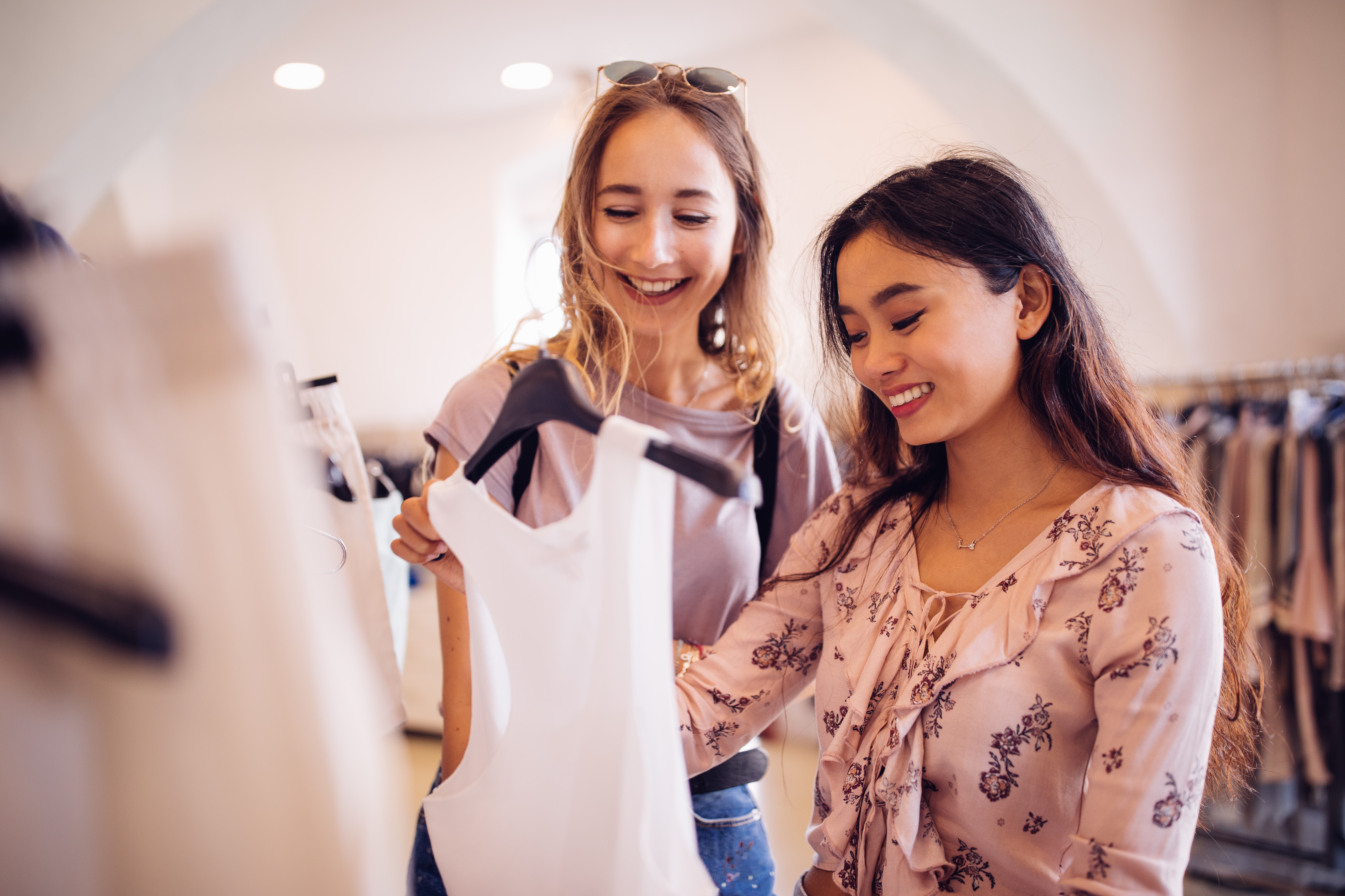Clientes mulheres observando uma camiseta branca em loja