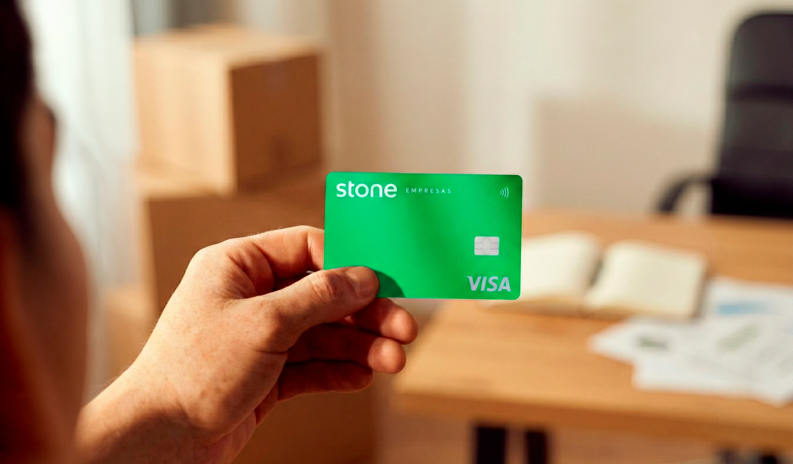 Mão segurando cartão de crédito para CNPJ da Stone