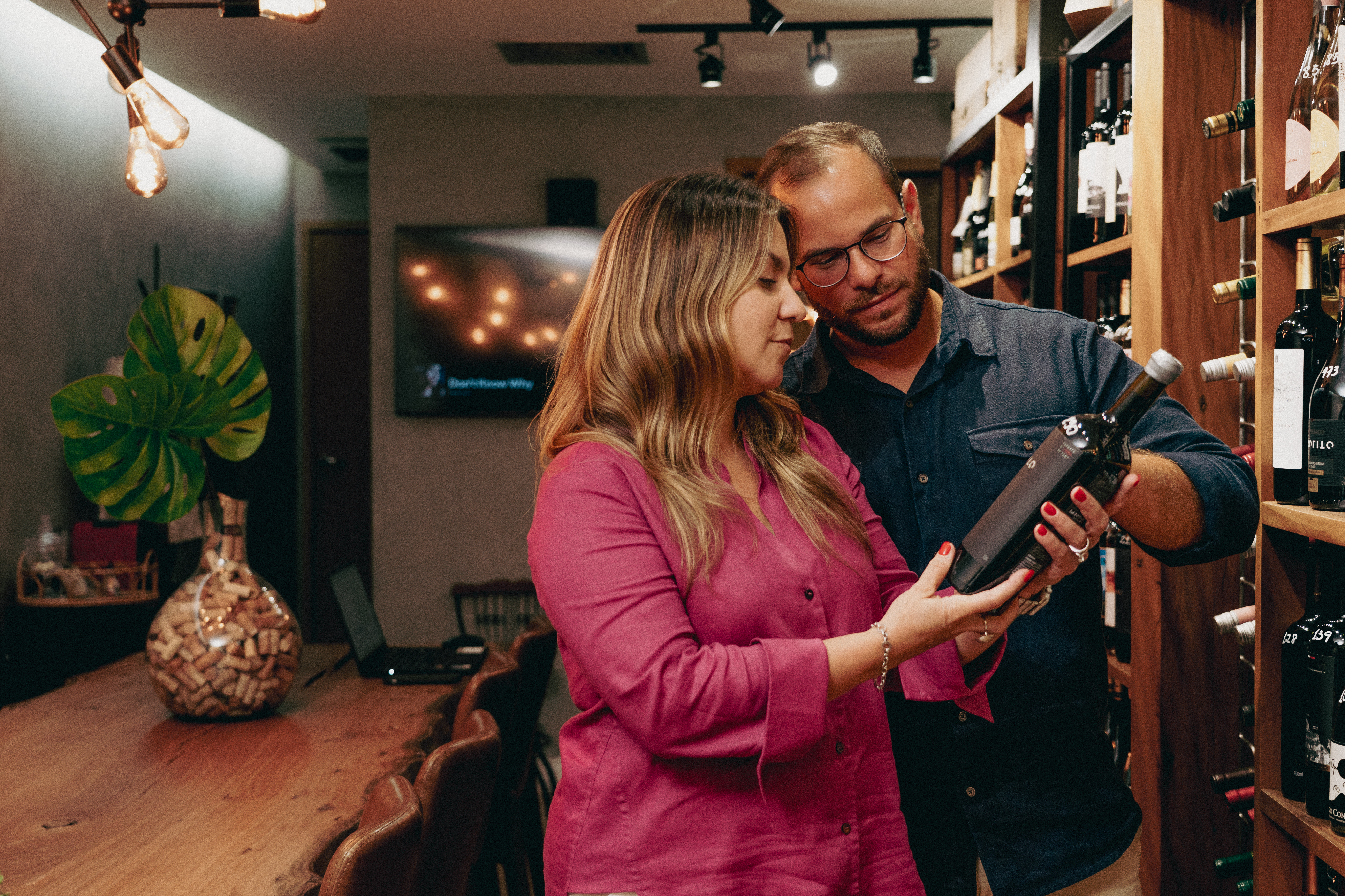 casal olhando uma garrafa de vinho