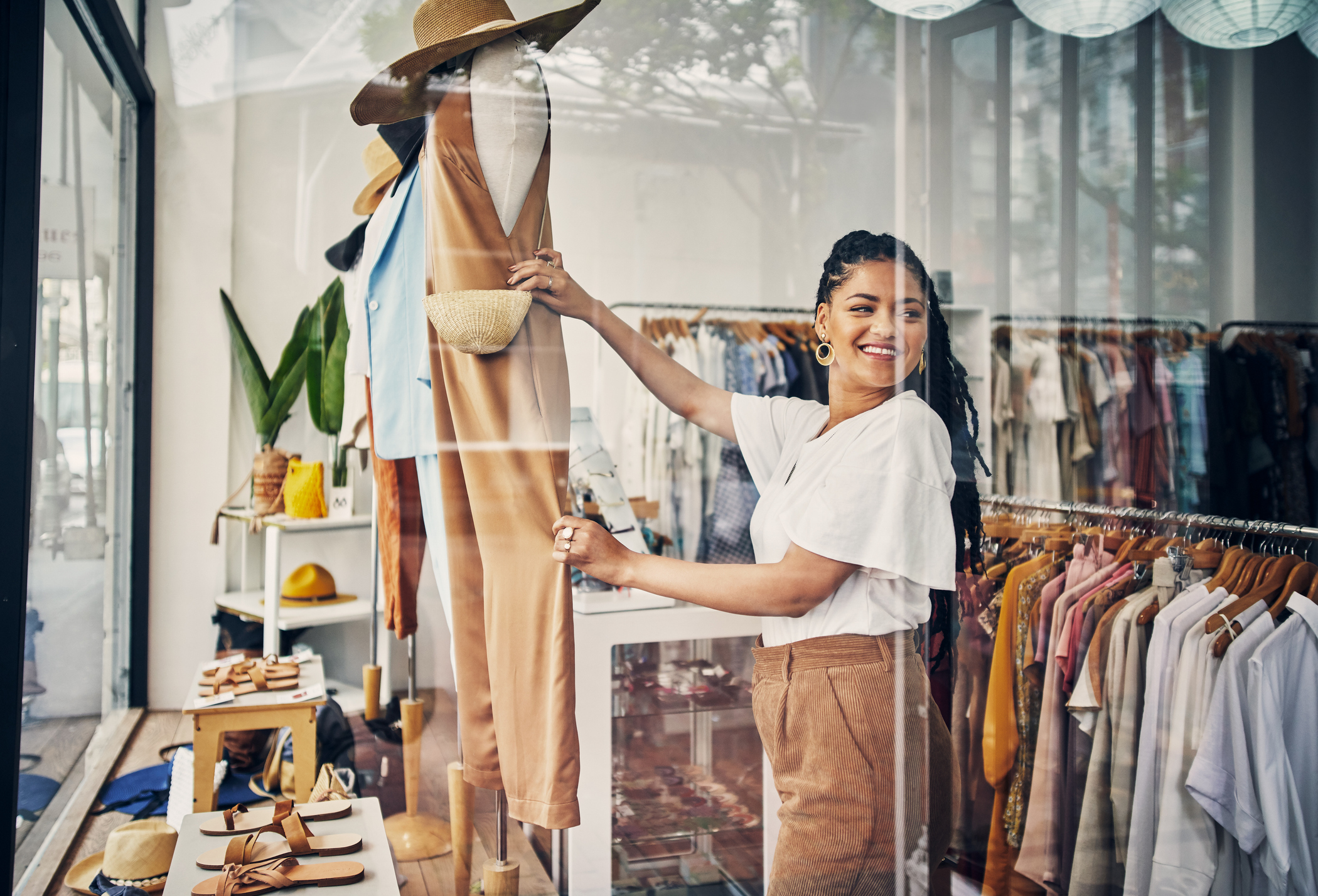 Empreendedora montando vitrine de loja de roupas