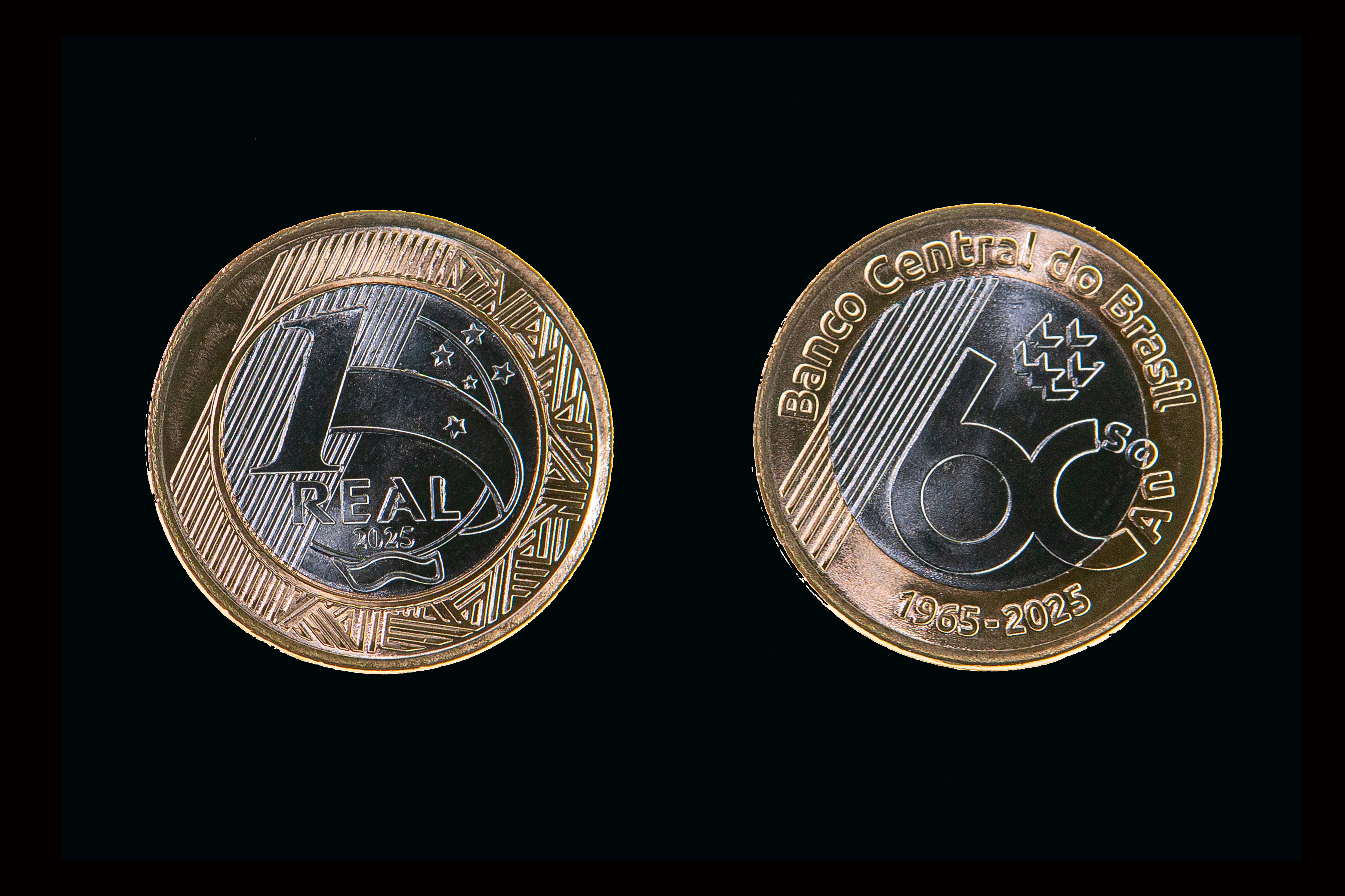 novas moedas de um real do Banco Central sob fundo preto