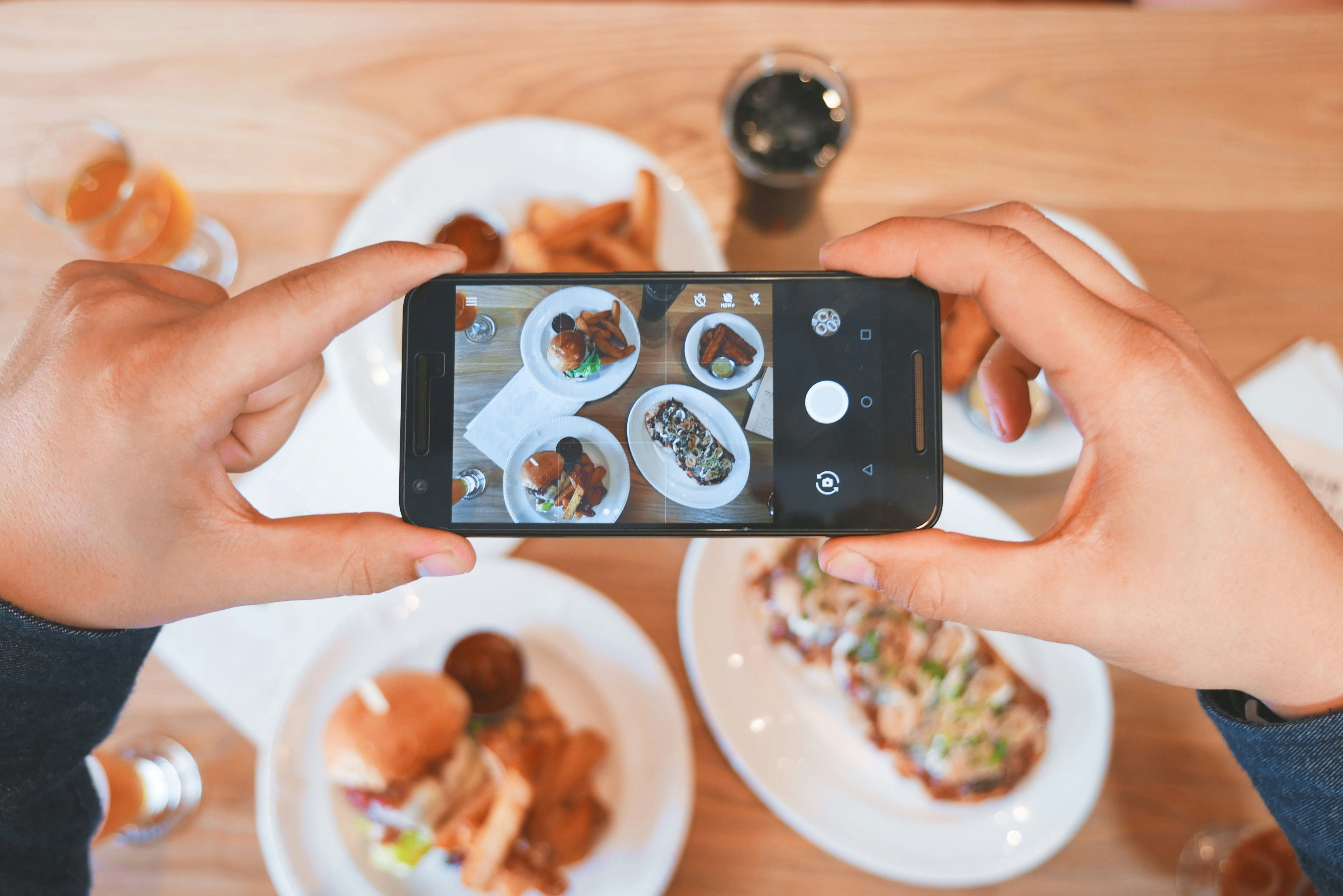 Mulher tirando foto de comida no celular para aumentar os seguidores no Instagram