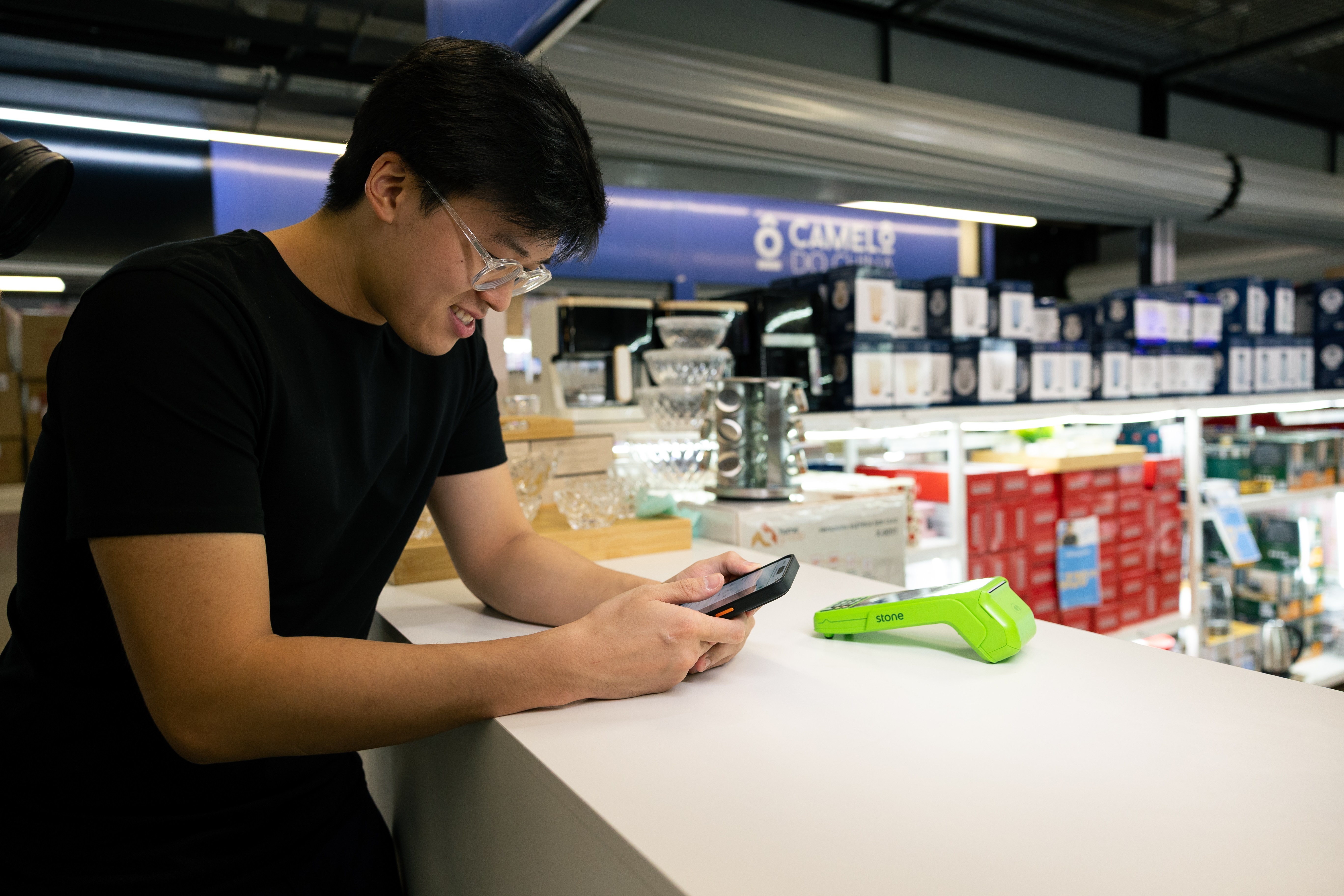 Empreendedor abrindo conta PJ no celular em balcão de loja
