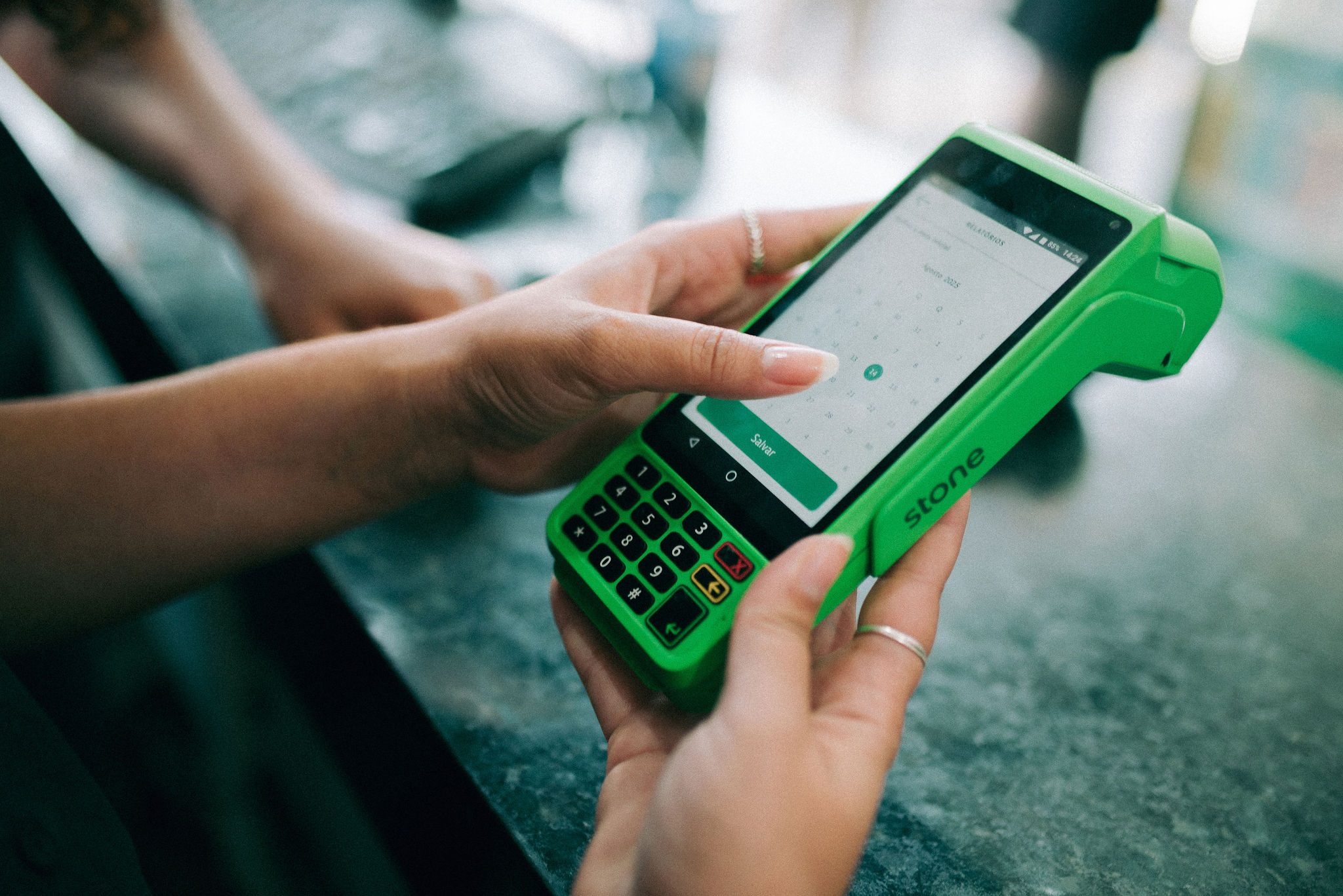 Mulher mexendo em maquininha de cartão
