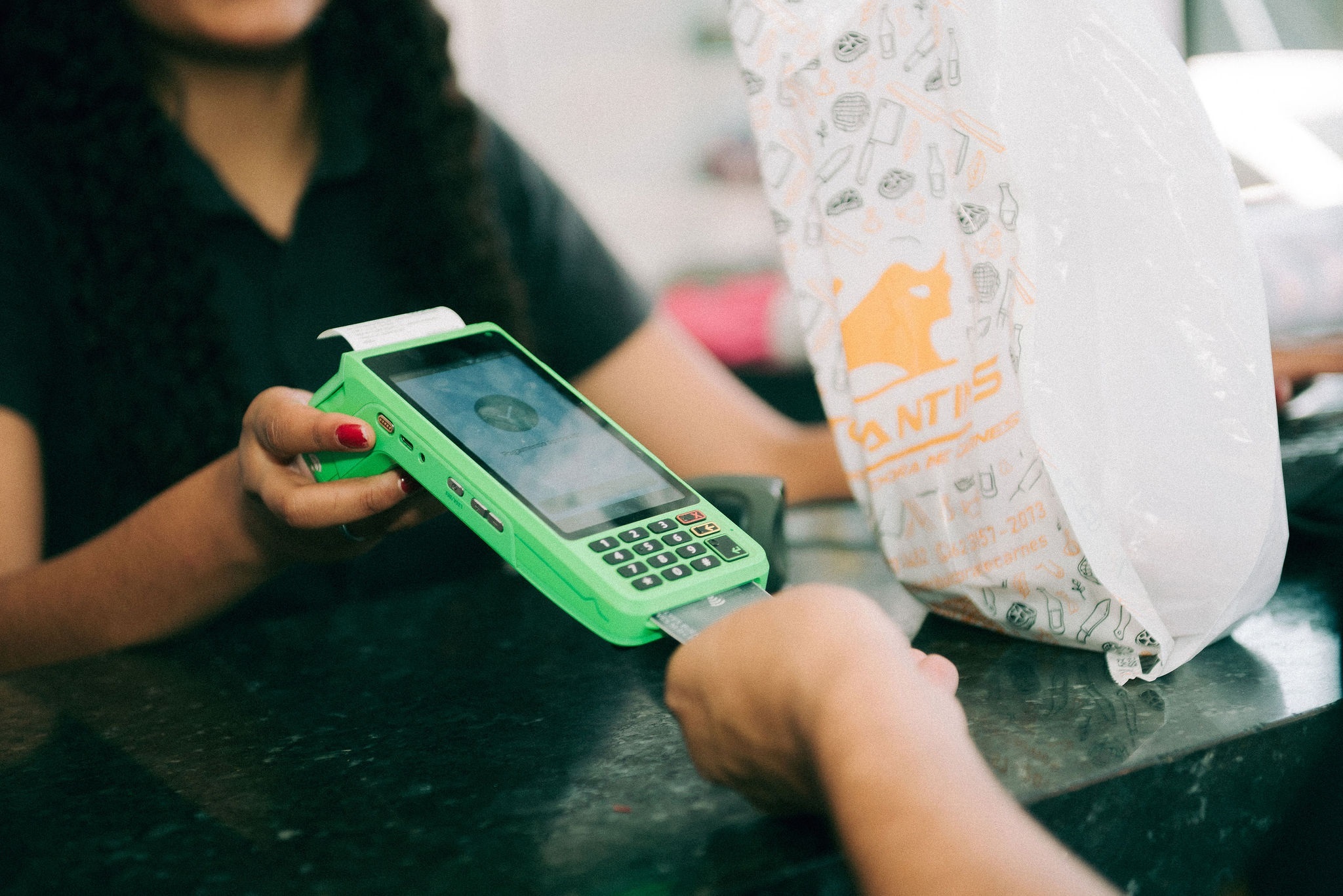 Cliente pagando compra em maquininha de cartão Stone