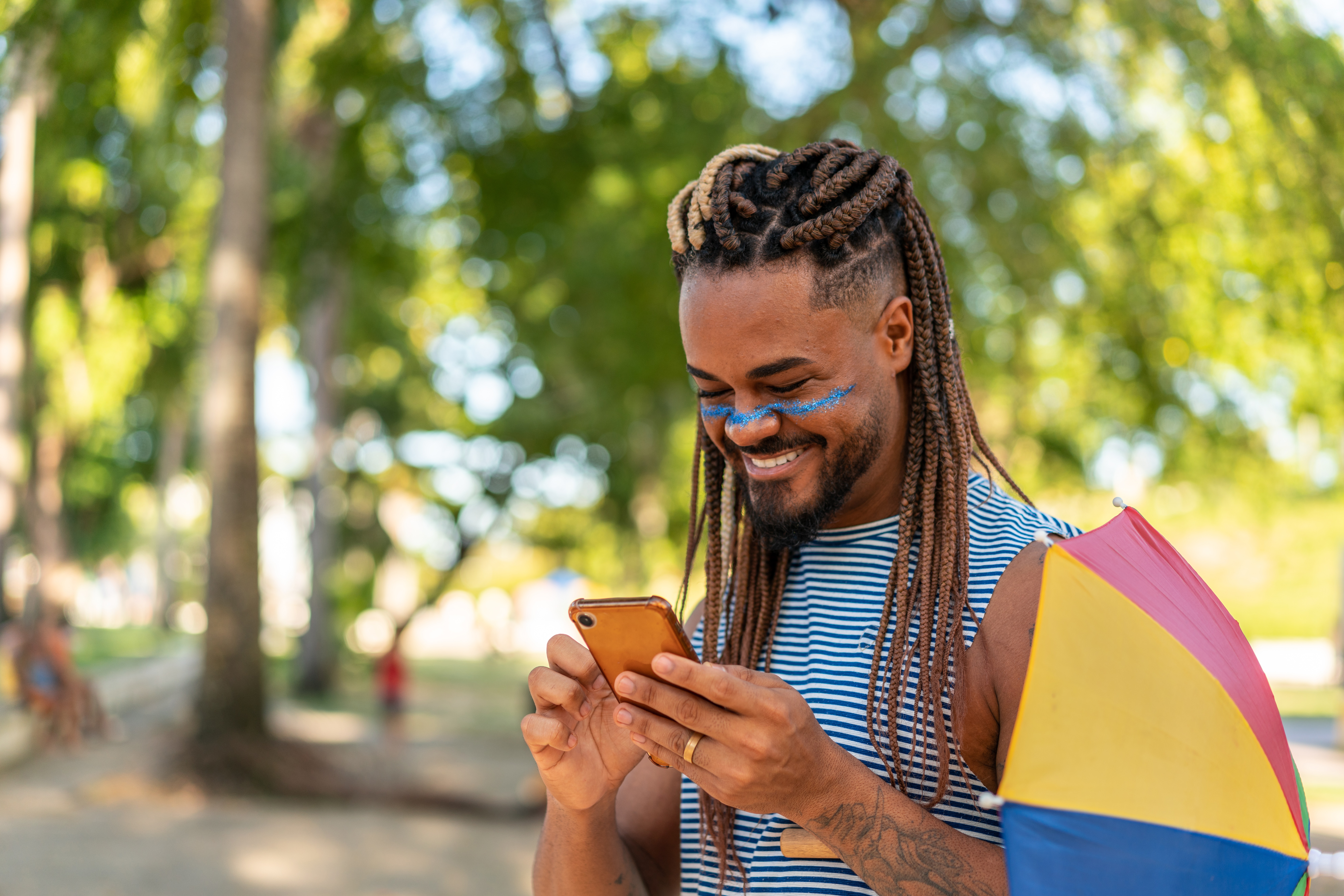 Homem fantasiado para o Carnaval vendo mensagem recebida no celular
